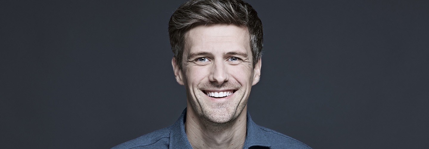 junger Mann lächelt ins Bild 